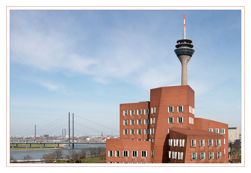 Neuer Zollhof 1
mit Rheinturm
Mit seiner terrakottafarben  verklinkerten  Fassade  erinnert  das  Gebäude  an  den  früheren Zollhof, ein viergeschossiges Lagerhaus, das zwischen 1896 und 1992 auf diesem Grundstück stand. laut aknw.de

Schlüsselwörter: Düsseldorf; Medienhafen; Neuer Zollhof; Rheinturm;