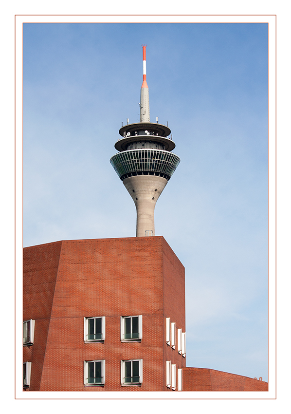 Neuer Zollhof 1
mit Rheinturm
Wie  Stapelware ragt der Neue Zollhof 1, ein aus 418 tragenden Stahlbeton-Fertigteilen bestehendes Bauwerk,  am Rand des Hafenbeckens auf.

Schlüsselwörter: Düsseldorf; Medienhafen; Neuer Zollhof; Rheinturm;