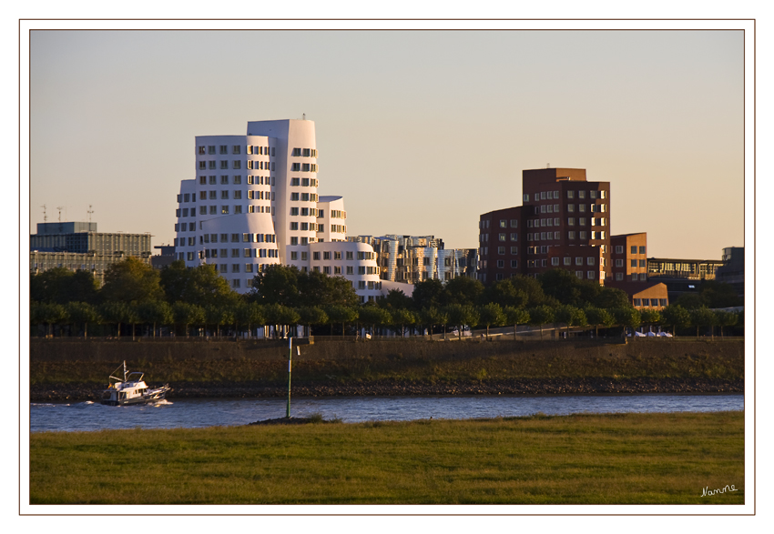 Blick übers Wasser
Diese Türme sind krumm; sie sind schief, sie sind verwinkelt und verschachtelt. Das Kunst- und Medienzentrum Rheinhafen, besser bekannt unter dem Namen Gehry-Bauten, wurde 1999 an der Stelle des alten Zollhof fertiggestellt. Der amerikanische Architekt Frank O. Gehry hat sich weltweit mit seiner dekonstruktivistischen Architektur einen Namen gemacht.
Schlüsselwörter: Gehry          Medienhafen       