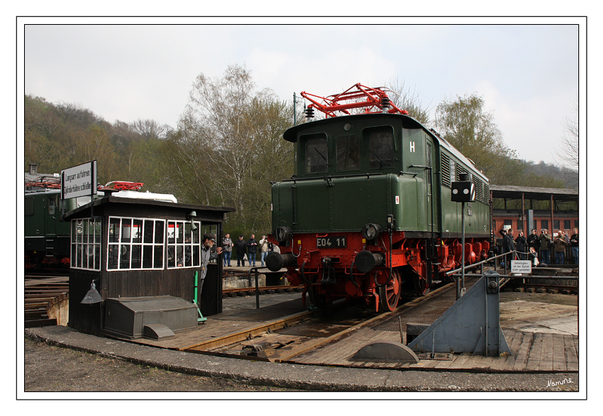 An der Drehscheibe
Bei dem Programmpunkt 2 werden alle Elektrolokomotiven nacheinander auf der Drehscheibe vorgeführt. Begonnen wird mit den E-Loks aus der Lokparade im Anschluss daran folgen die E-Loks aus dem Sand- und dem Kohlegleis. Die Loks werden mit einer Köf II (je nach Länge wird evtl. auch eine Köf III notwendig) auf die Scheibe gezogen.
Schlüsselwörter: Eisenbahnmuseum Bochum