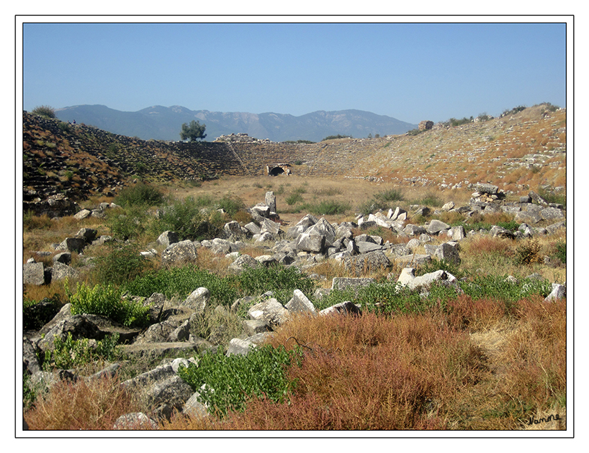 Stadion von Aphrodisias
Das elypsenförmige und an beiden Enden mit einem Halbkreis ausgestattete Bauwerk hatte Sitzreihen für 30.000 Zuschauer.
Die 22 Sitzreihen wurden auf die schrägen Gewölbe platziert, in denen sich damals Geschäfte und Lagerdepots befanden. Der Zuschauerraum wurde durch tunnelförmige Eingänge betreten.
Schlüsselwörter: Türkei Aphrodisias