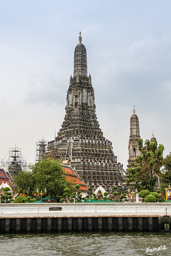 Bootstour in Bangkok
Blick vom Boot aus auf den Tempel der Morgenröte
Der Wat Arun-Tempel liegt am westlichen Ufer des Chaophraya-Flusses und stammt aus dem 17. Jahrhundert. Er hat einen mit bunten Keramikkacheln verzierten, 79 m hohen Turm, was ihn zu einem markanten Wahrzeichen am Fluss macht. Hier war der Smaragdbuddha zuerst untergebracht, bevor er 1785 zum Wat Phra Kaeo-Tempel gebracht wurde. 
laut Wikipedia
Schlüsselwörter: Thailand Bangkok Bootstour