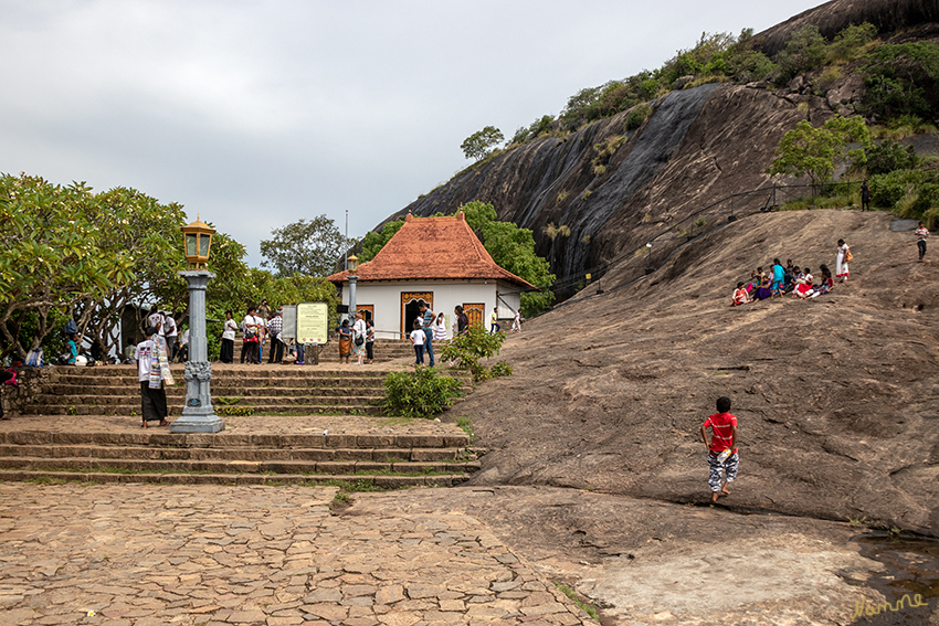 Dambulla - Eingangsbereich zu den Höhlen
Insgesamt befinden sich in dem 160m hohen Felsenberg (links) über 80 Höhlen, die im Jahr 1938 durch Gänge und Portale für die Öffentlichkeit zugänglich gemacht wurden.
Die Tempelanlagen sind unter dem Namen "Goldener Tempel von Dambulla" seit 1991 Weltkulturerbe der UNESCO. 
Schlüsselwörter: Sri Lanka, Dambulla