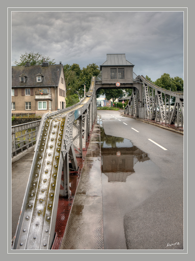 Spiegelung
Die Deutzer Drehbrücke steht unter Denkmalschutz. Ähnlich der nur wenige Jahre zuvor erbauten Drehbrücke im Rheinauhafen werden die 177 Tonnen Eigengewicht ihres Überbaus hydraulisch aus der Ruheposition gehoben und dann mittels eines Elektromotors gedreht.
Schlüsselwörter: Deutzer Drehbrücke Köln
