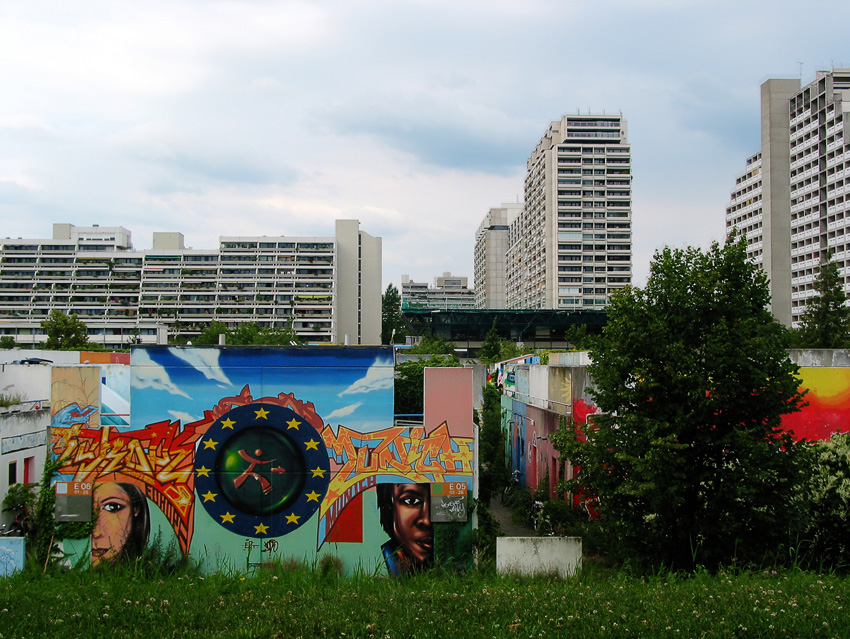 Gegensätze 
Die bunt bemalten, lauschig bewachsenen Bungalows im Olympiadort sind zur Zeit noch Studentenwohnungen.
(Abriss 2008?)
Schlüsselwörter: München    Olympiadorf     bunt      Bungalow