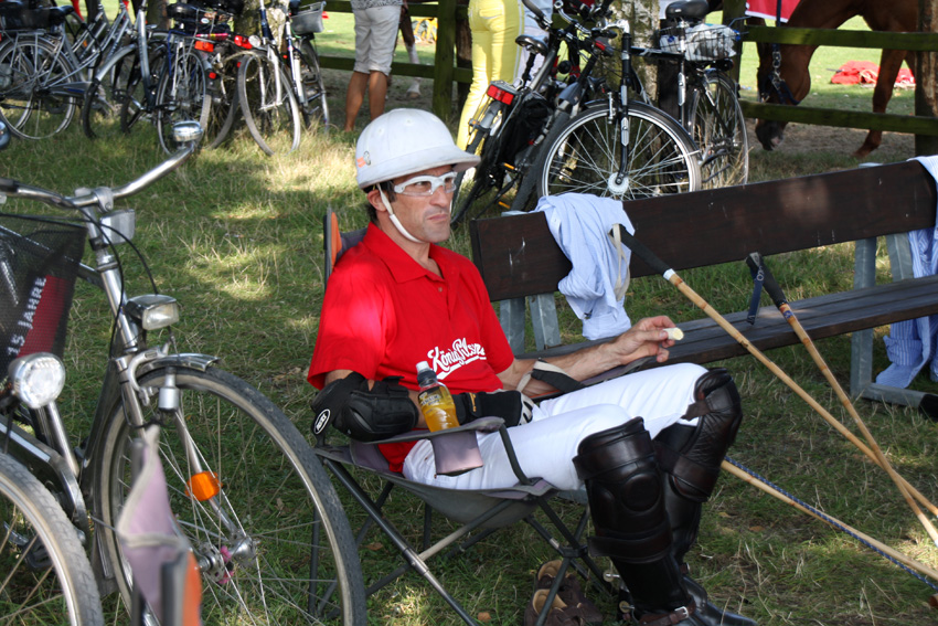 Polo
Der Spieler trägt zwingend vorgeschrieben einen Helm. Polohelme fallen breiter aus als klassische Reithelme, das hat aber rein ästhetische Gründe, weil der Polohelm seine Wurzeln in den Tropenhelmen der Kolonialzeit hat.
Entgegen der Legende stammt das kurzärmelige Polohemd - eine Erfindung der französischen Tennislegende René Lacoste - nicht aus dem Polosport, sondern aus dem Tennis und wurde erst nach 1933 sukzessive von anderen Sportarten wie dem Polo übernommen.
Die typischerweise braunen und mit Reißverschluss ausgestatteten Polostiefel sind oft mit Sporen versehen.
Schlüsselwörter: Polo