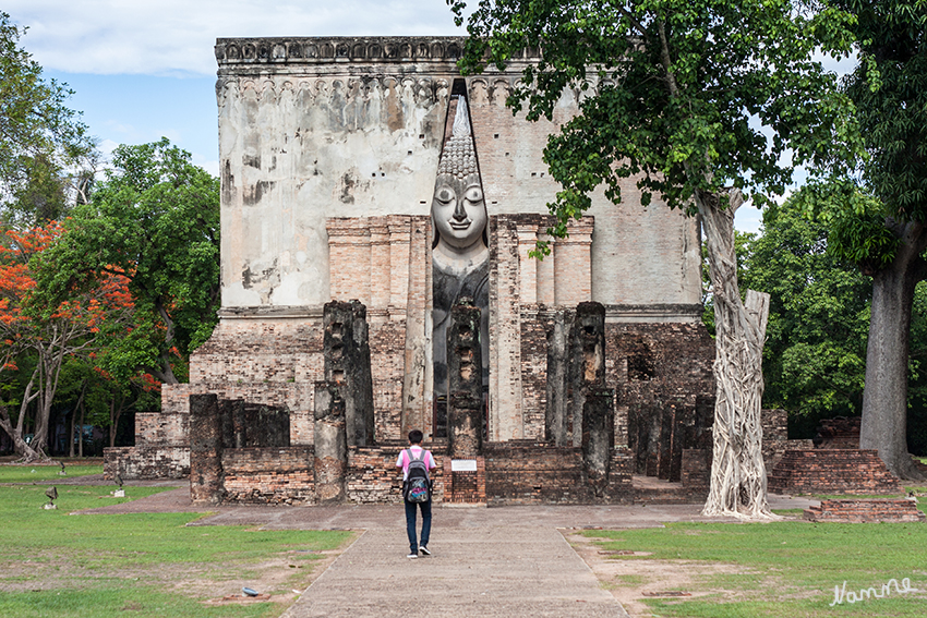 Wat Sri Chum
Der Tempel besteht aus einem quadratischen Mondop der eine gigantische Buddhastatue, den Phra Achana, enthält. Die Statue ist älter, als der Mondop, da sie schon in Ramkamhaengs Inschriftenstein erwähnt wird. Der hohe Eingang erlaubt schon von weitem einen Blick auf das Gesicht der riesigen Buddhastatue im Inneren.

Schlüsselwörter: Thailand Wat Sri Chum