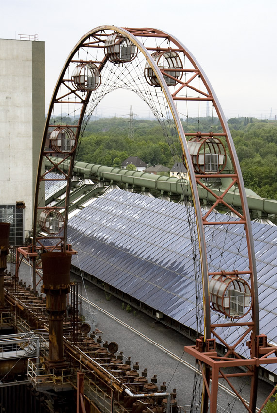 Sonnenrad
Das sogenannte Sonnenrad auf der "schwarzen Seite" ist ein nabenloses Riesenrad, das mitten durch die ehemals 1.000 Grad heißen Öfen der Kokerei und bis hinauf in luftige Höhen fährt.
Schlüsselwörter: Kokerei Zollverein                  Sonnenrad                         Essen