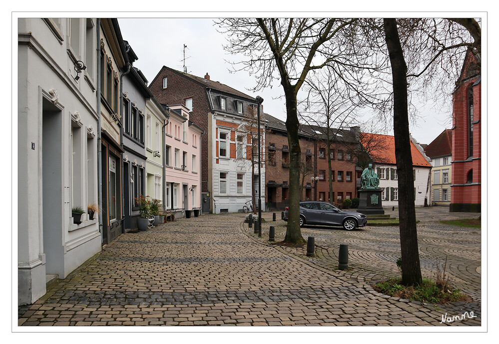 Kempen
Um die Kirche herum erstreckt sich ein kreisförmiger Platz, die alte Immunität, die jahrhundertelang als Kirchhof benutzt wurde. An der Grenze der alten Immunität, der heutigen Straße "An St. Marien", entstand möglicherweise schon im frühen Mittelalter die erste Bebauung Kempens. 
Zentral auf dem Kirchplatz beheimatet ist das Thomasdenkmal, gestaltet von dem Aachener Bildhauer, Lambert Piedboeu. laut kempedia
