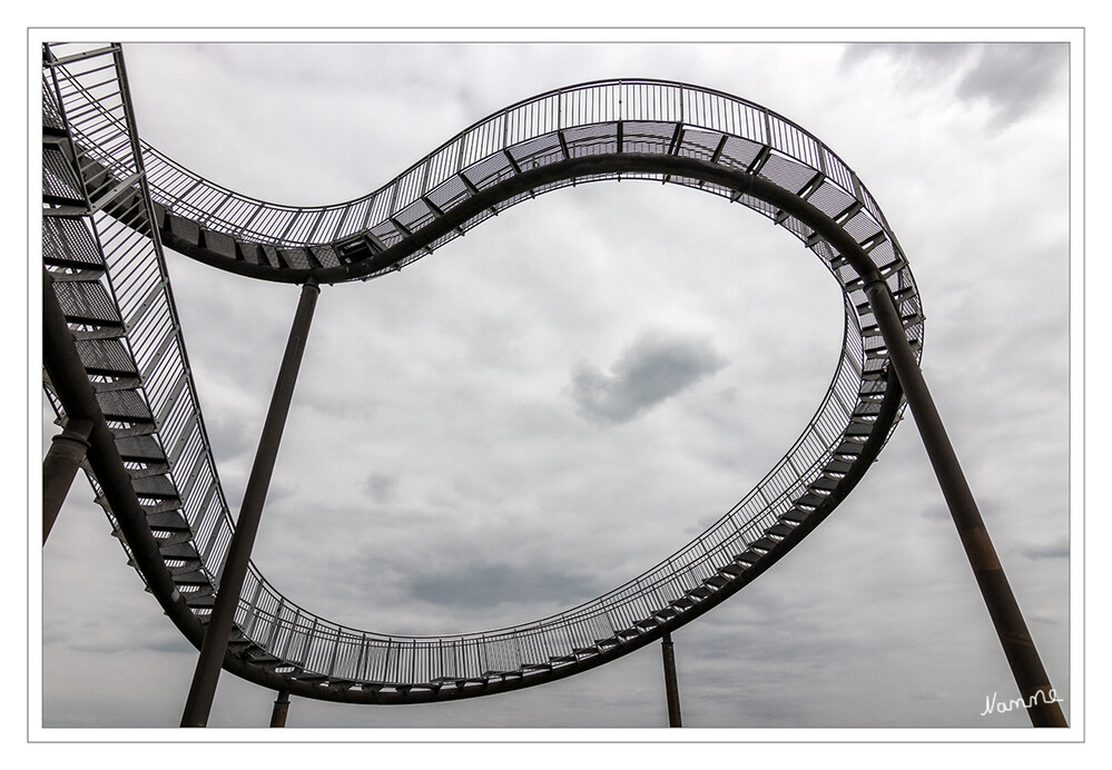 Detail Tiger and Turtle
Mit dem verzinkten Stahl als Baumaterial hat die Skulptur einen historischen Bezug zum Standort. Das Bauwerk mit einer Grundfläche von 40 mal 41 Metern ist etwas mehr als 20 Meter hoch (Oberkante Looping). Es kann bis auf den Looping vollständig begangen werden, was bedeutet, dass man den Weg in beiden Richtungen bis zum Einstiegspunkt wieder zurücklaufen muss. laut Wikipedia
