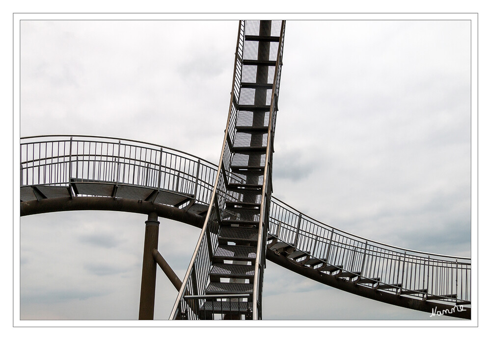 Detail Tiger and Turtle
Mit dem verzinkten Stahl als Baumaterial hat die Skulptur einen historischen Bezug zum Standort. Das Bauwerk mit einer Grundfläche von 40 mal 41 Metern ist etwas mehr als 20 Meter hoch (Oberkante Looping). Es kann bis auf den Looping vollständig begangen werden, was bedeutet, dass man den Weg in beiden Richtungen bis zum Einstiegspunkt wieder zurücklaufen muss. laut Wikipedia
